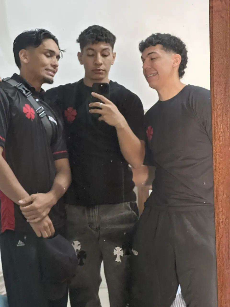 Los tres del equipo posando juntos frente al espejo, ya con el uniforme de la competencia.