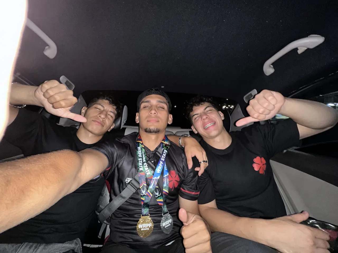 Los tres celebrando en el auto, con las medallas puestas, después de salir de la sede.