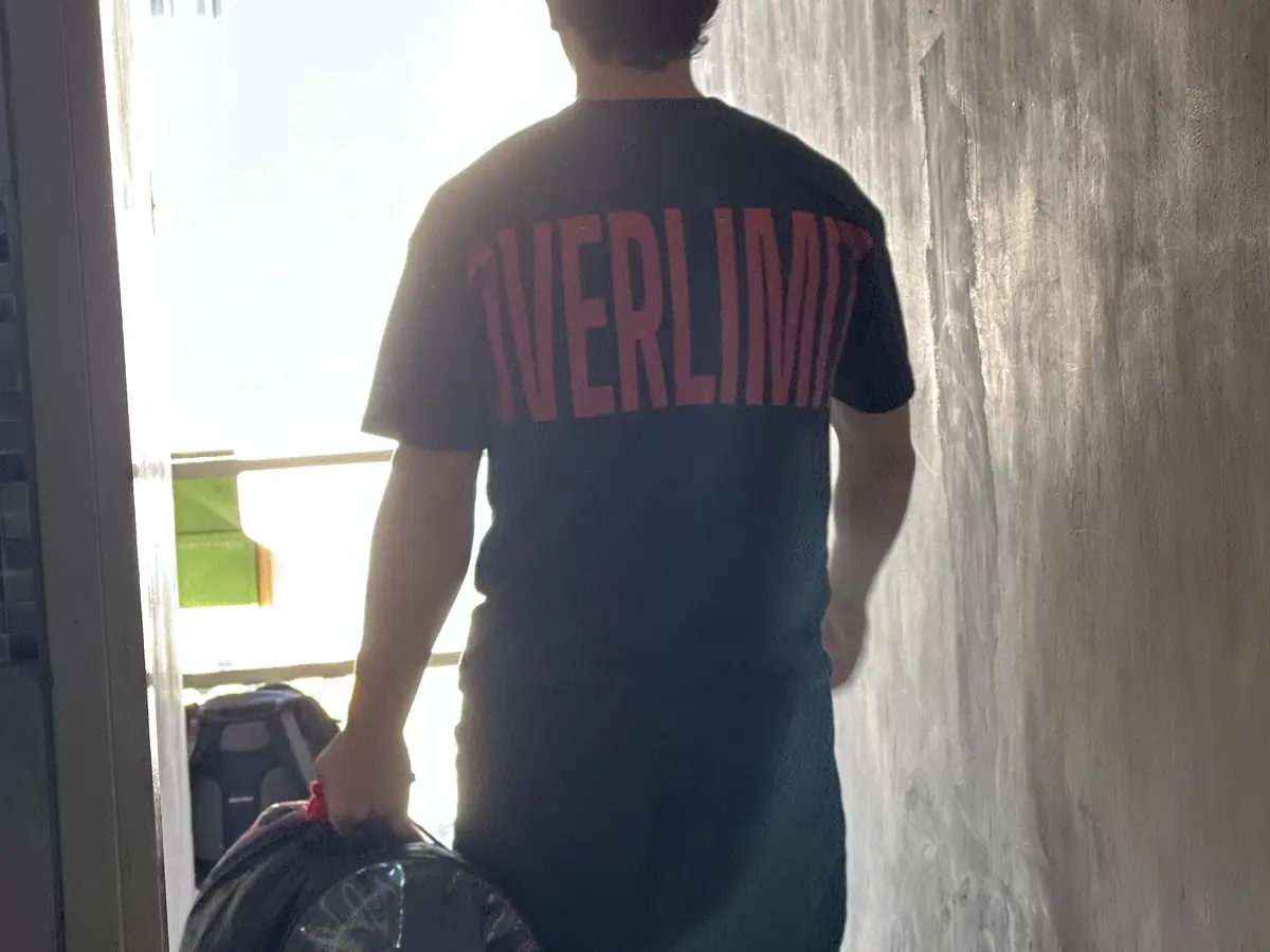 Ali Rondón, entrenador de fuerza de Overlimit, entrando a la sala de entrenamiento con el bolso de discos.
