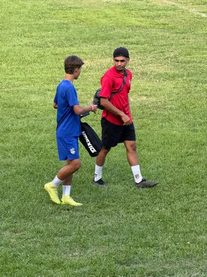 Andrés Correia recorre la cancha con su bolso de trabajo durante una sesión en el campo.
